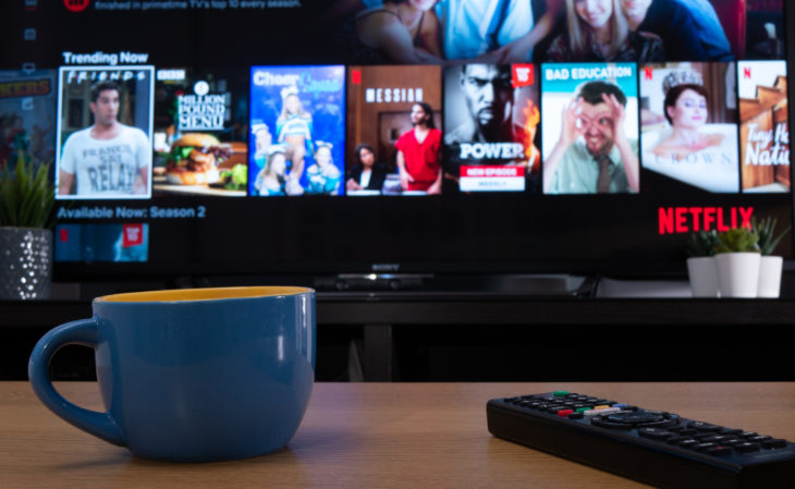 UK, Jan 2020: Netflix trending now menu displayed on television set in home setting with mug