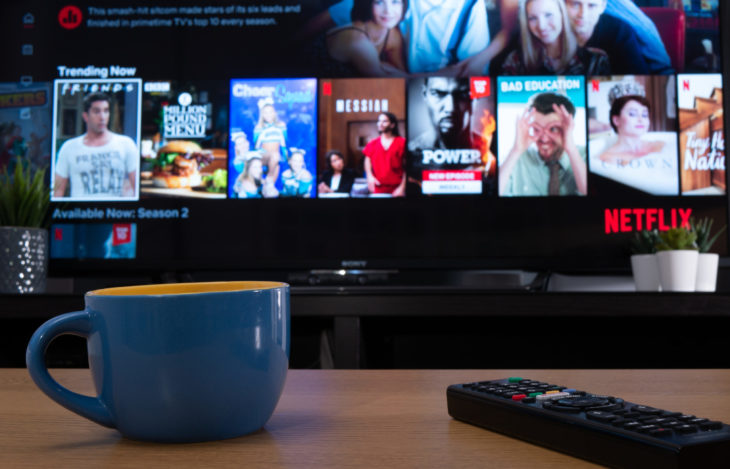 UK, Jan 2020: Netflix trending now menu displayed on television set in home setting with mug